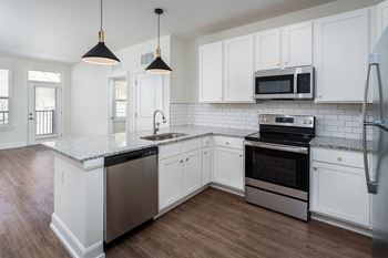a kitchen with white cabinets and stainless steel appliances